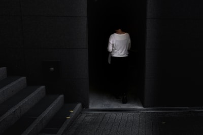 一名妇女走在大楼内灰色楼梯附近